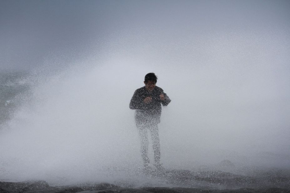 A resident stands near waves in Legazpi City, southeast of Manila, on July 15. Rammasun is expected to stay at category 3 strength until its final landfall near the China-Vietnam border.