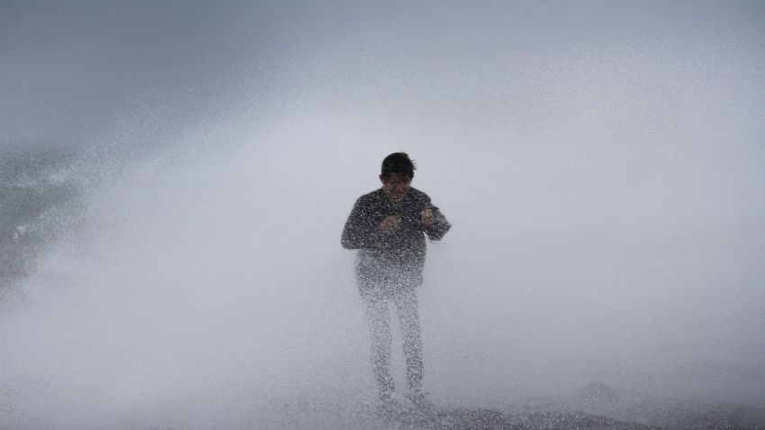A resident stands near waves in Legazpi City, southeast of Manila, on July 15, 2014 as authorities warned of approaching Typhoon Rammasun. Thousands of people fled their homes and ships sheltered from heavy seas in the Philippines on July 15, as the first major storm of the rainy season strengthened into a typhoon. AFP PHOTO/Charism SayatCharism SAYAT/AFP/Getty Images