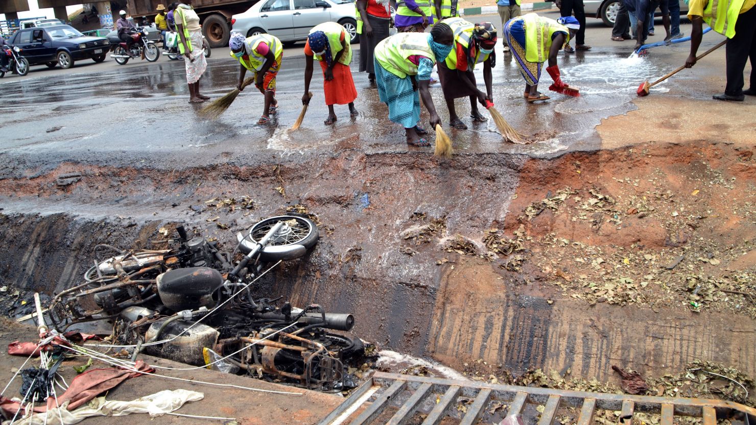 Nigerian workers clean the site of a bomb blast in Abuja on April 15, 2014.