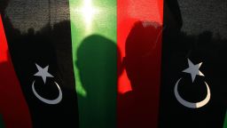Caption:Shadows of Libyan protesters is seen on the national flag during a rally in support of a rogue former general whose forces have launched a 'dignity' campaign to crush jihadist militias on May 23, 2014 in Benghazi, eastern Libya. Ex-general Khalifa Haftar has garnered growing support amid frustration at the lawlessness in Libya three years after the overthrow of dictator Moamer Kadhafi. AFP PHOTO / ABDULLAH DOMA (Photo credit should read ABDULLAH DOMA/AFP/Getty Images)