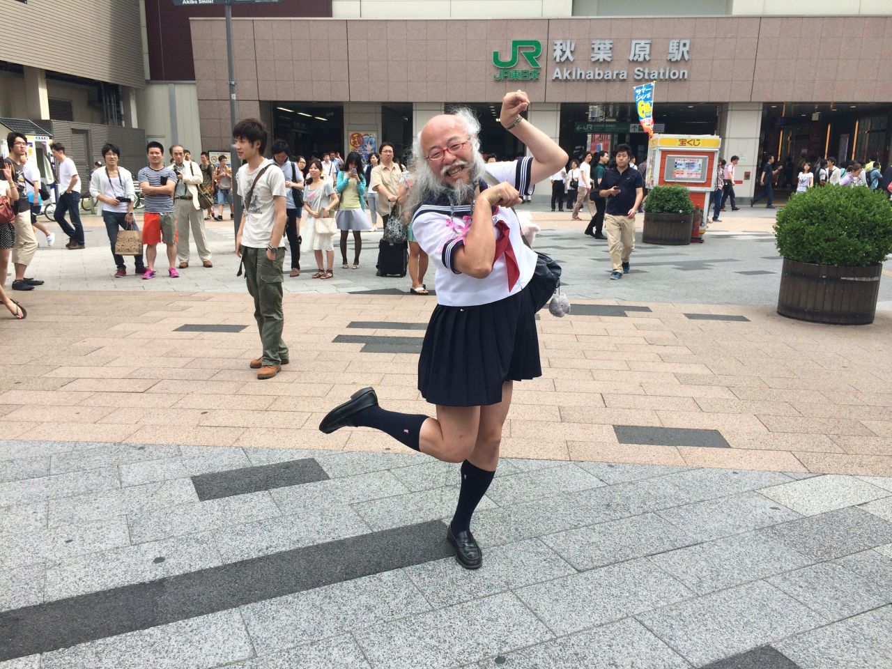 Hideaki Kobayashi, 51, strikes his signature "cat" pose outside Akihabara station in Tokyo on Sunday July 13.  Underneath the Japanese schoolgirl facade, he is a patent-holding computer engineer and accomplished photographer.