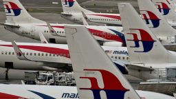 Airport groundstaff walk past Malaysia Airlines planes parked on the tarmac at the Kuala Lumpur International Airport in Sepang on June 17, 2014. Malaysia's government pledged on June 16 it 'will not rest' until missing flight MH370 is found but relatives said on the 100th day since the plane's disappearance that they wanted answers, not more promises.   AFP PHOTO/ Manan VATSYAYANA        (Photo credit should read MANAN VATSYAYANA/AFP/Getty Images)