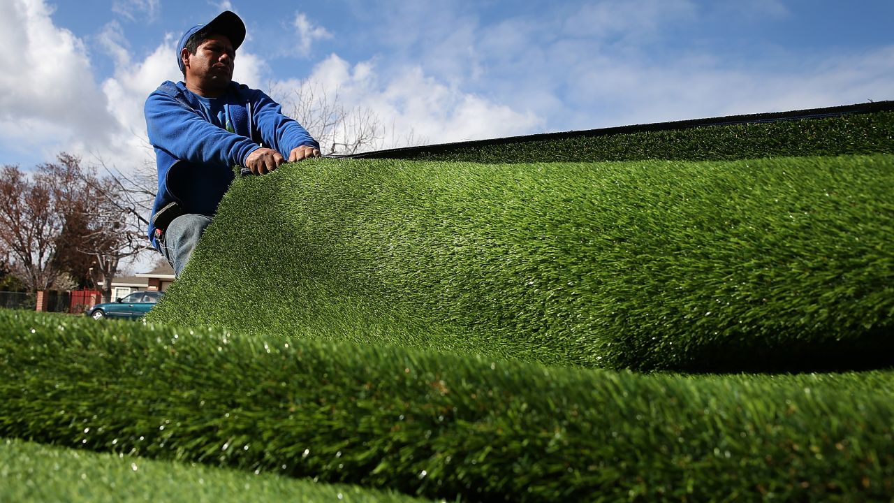 A worker installs an artificial lawn in front of an apartment building in San Jose in January 2014.