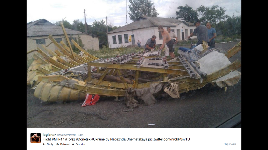People inspect wreckage thought to be from Malaysia Airlines Flight 17 in Ukraine. This image was posted to Twitter.