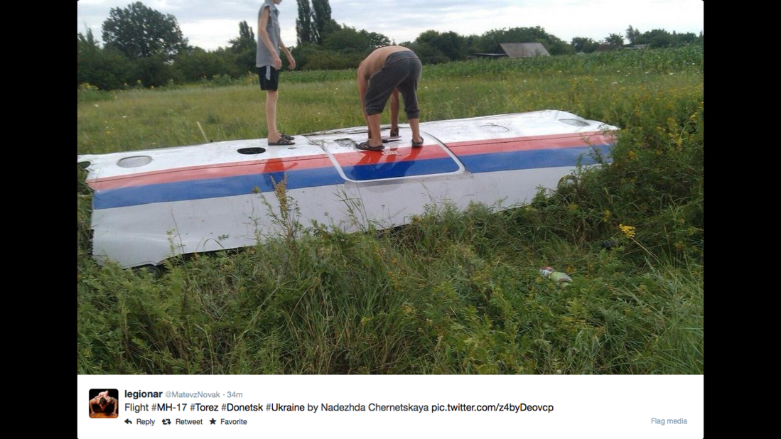 People inspect a piece of wreckage believed to be from Malaysia Airlines Flight 17. This image was posted to Twitter.