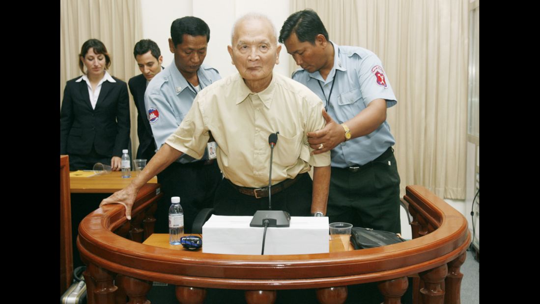 Nuon Chea, a former leader in the Khmer Rouge reign of terror and right hand man to Pol Pot, gets help to stand up in the dock before a hearing in 2008 at the U.N.-backed Cambodian war crimes court in Phnom Penh. A verdict is expected in August on Chea's indictment over atrocities.