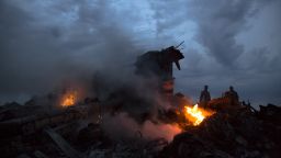 People walk amongst the debris at the crash site of a passenger plane near the village of Grabovo, Ukraine, Thursday, July 17. Ukraine said a passenger plane carrying 295 people was shot down Thursday as it flew over the country, and both the government and the pro-Russia separatists fighting in the region denied any responsibility for downing the plane.