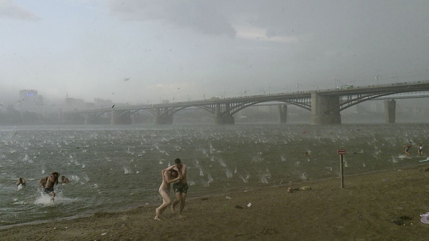 People run for shelter from <a href="http://edition.cnn.com/video/?/video/weather/2014/07/14/siberia-freak-hail-storm.ruslan-sokolov-the-siberian-times&video_referrer=" target="_blank">a hailstorm</a> at the Ob River in the Siberian city of Novosibirsk, Russia, on Saturday, July 12.
