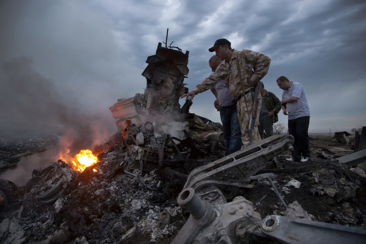 People inspect the crash site on Thursday, July 17, 2014.