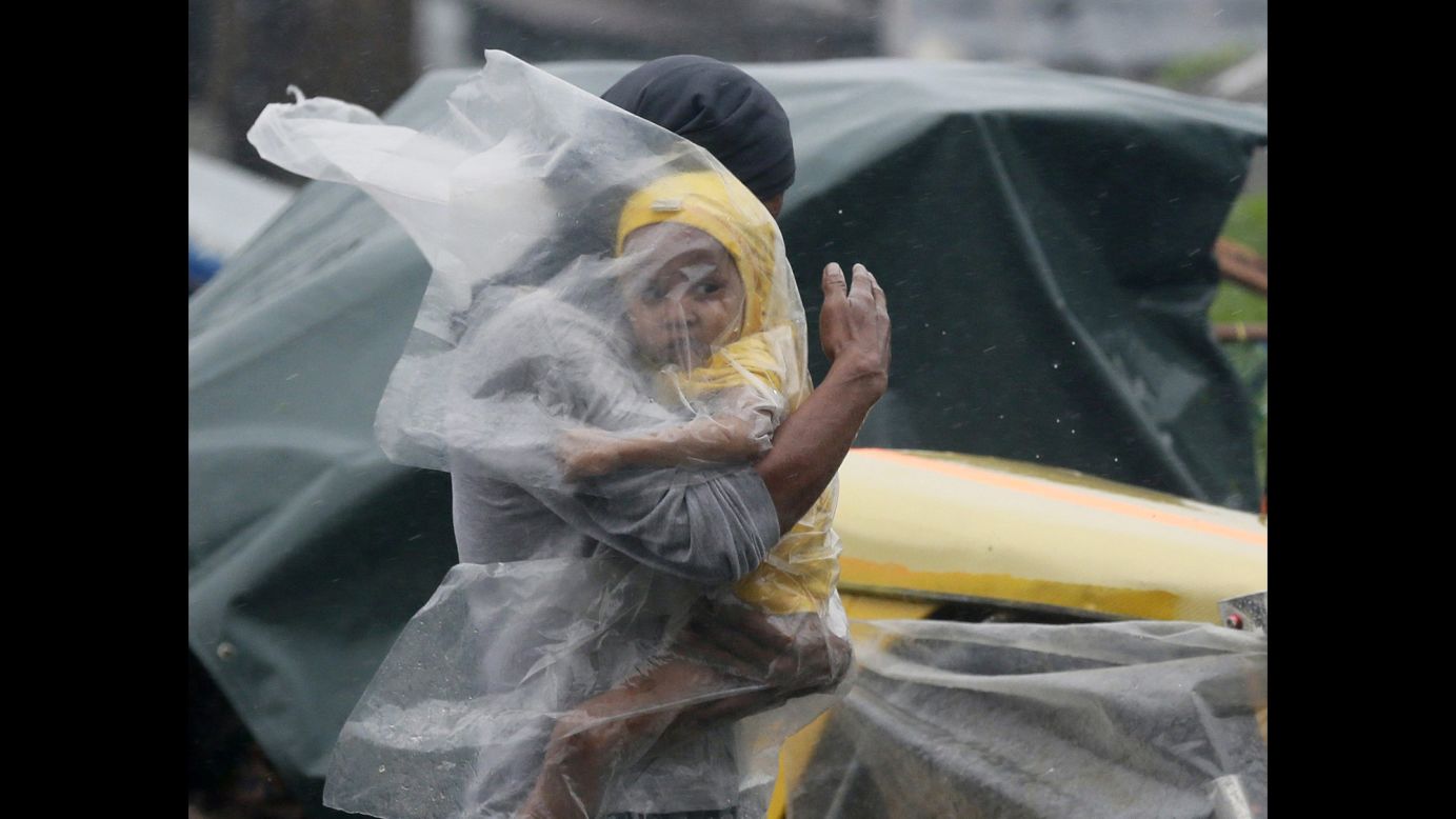 A Filipino father shelters his child from the strong winds and rain brought by <a href="http://www.cnn.com/2014/07/15/asia/gallery/typhoon-rammasun/index.html" target="_blank">Typhoon Rammasun</a> in Manila on Wednesday, July 16. The Philippines' first major typhoon of the season has killed more than three dozen people.