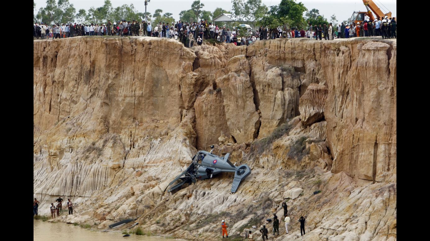 Soldiers use a crane to retrieve parts of a military helicopter from a pond after it crashed on the outskirts of Phnom Penh, Cambodia, on Monday, July 14. Four people were killed in the crash and a fifth person was seriously injured, according to media reports.