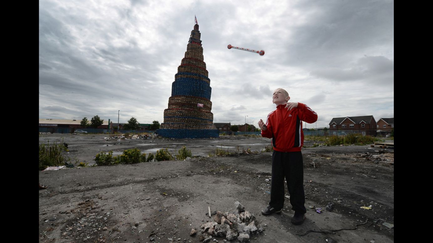 Curtis Walker throws a baton beside a Loyalist pyre before a bonfire in Belfast, Northern Ireland, on Friday, July 11. The 200-foot bonfire will mark the start of the 12th of July Orange parade, celebrating the protestant King William of Orange's victory over the Catholic English King James II at the Battle of the Boyne in 1690.