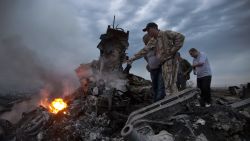 People inspect the crash site of a passenger plane near the village of Grabovo, Ukraine, Thursday, July 17, 2014.