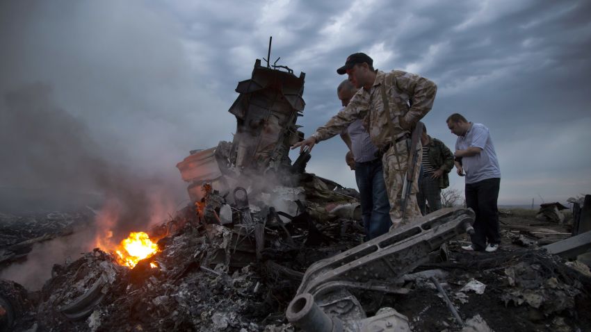 People inspect the crash site of a passenger plane near the village of Grabovo, Ukraine, Thursday, July 17, 2014.