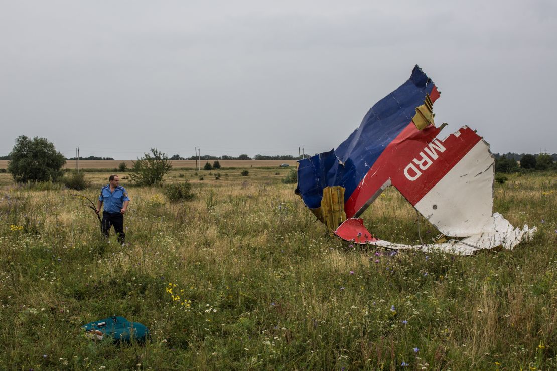 A Ukrainian police officer searches for human remains at the crash site in July 2014.
