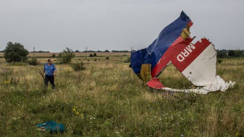 A Ukrainian police officer searches for human remains at the crash site in July 2014.
