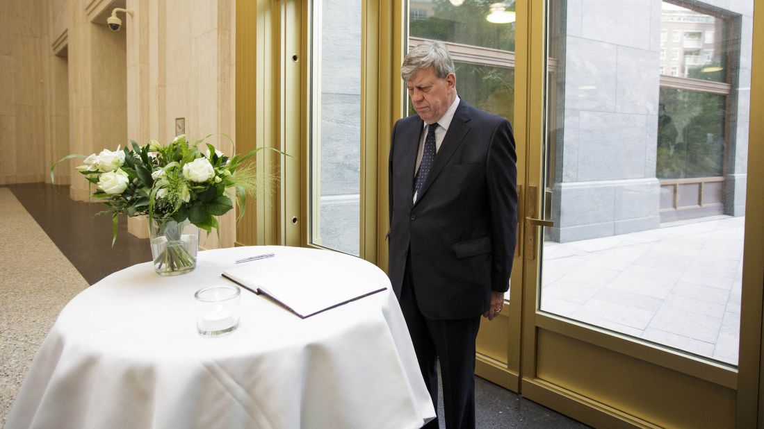 Dutch Justice Minister Ivo Opstelten observes a moment of silence after signing a condolence book in The Hague on July 18.