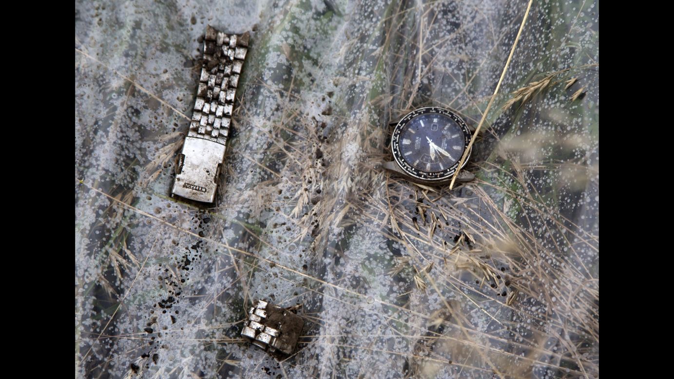 Pieces of a wristwatch lie on a plastic cover at the crash site. 
