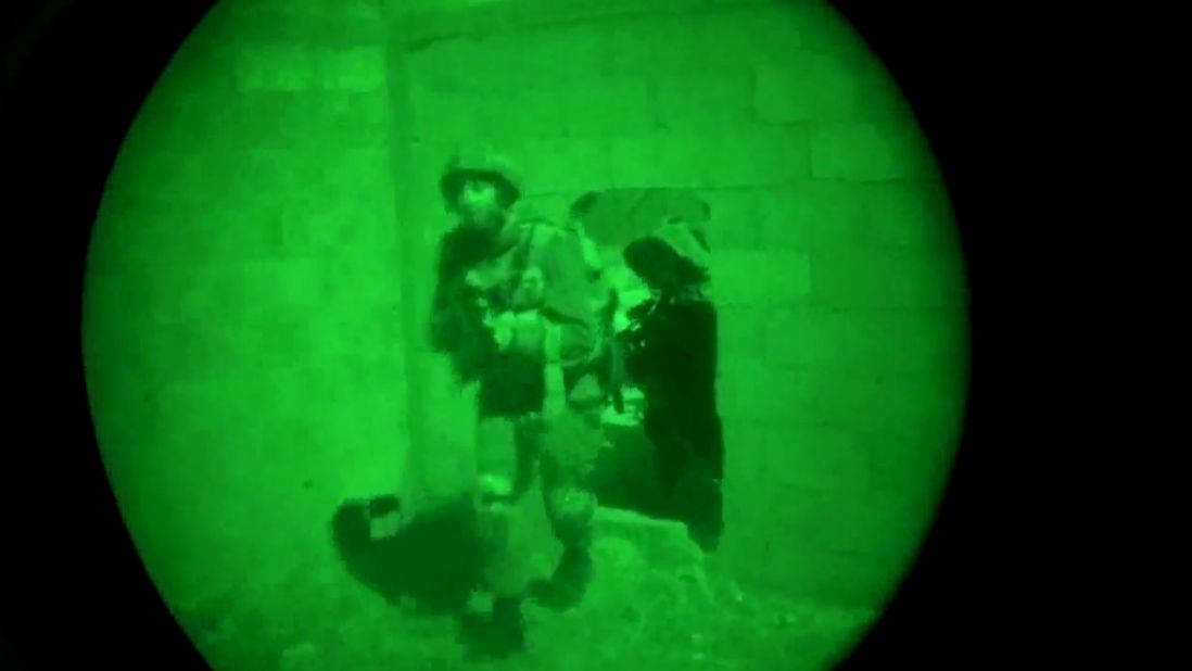 This image, made from video shot through a night-vision scope, was released by the Israeli military on July 18. It shows troops moving through a wall opening during the early hours of the ground offensive in Gaza. 