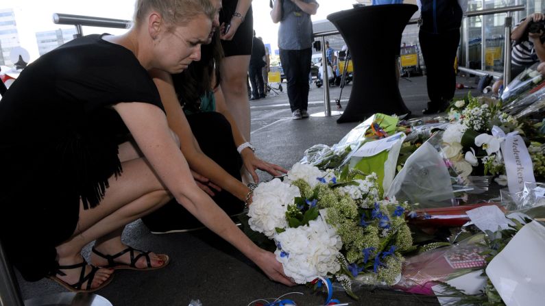 People lay flowers and light candles in front of the Schiphol airport on July 18.