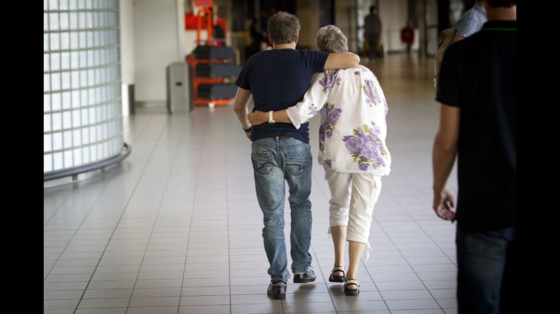 A couple walks through Schiphol Airport to a location where more information will be given regarding the flight on July 17, 2014. 