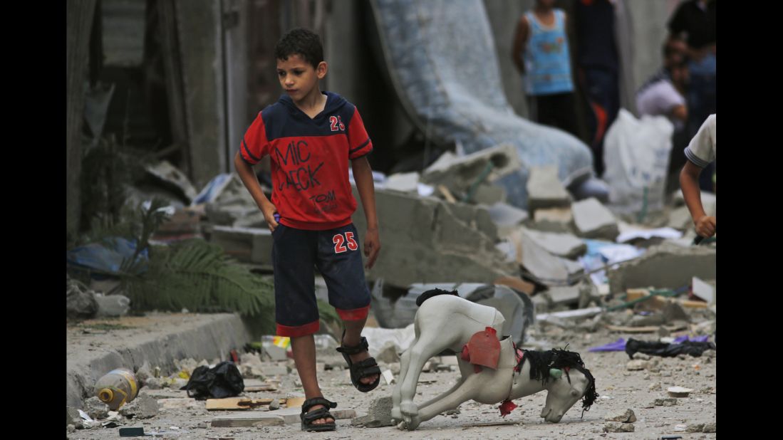 A Palestinian child walks on debris from a destroyed house following an overnight Israeli strike in Beit Lahiya on Saturday, July 19.