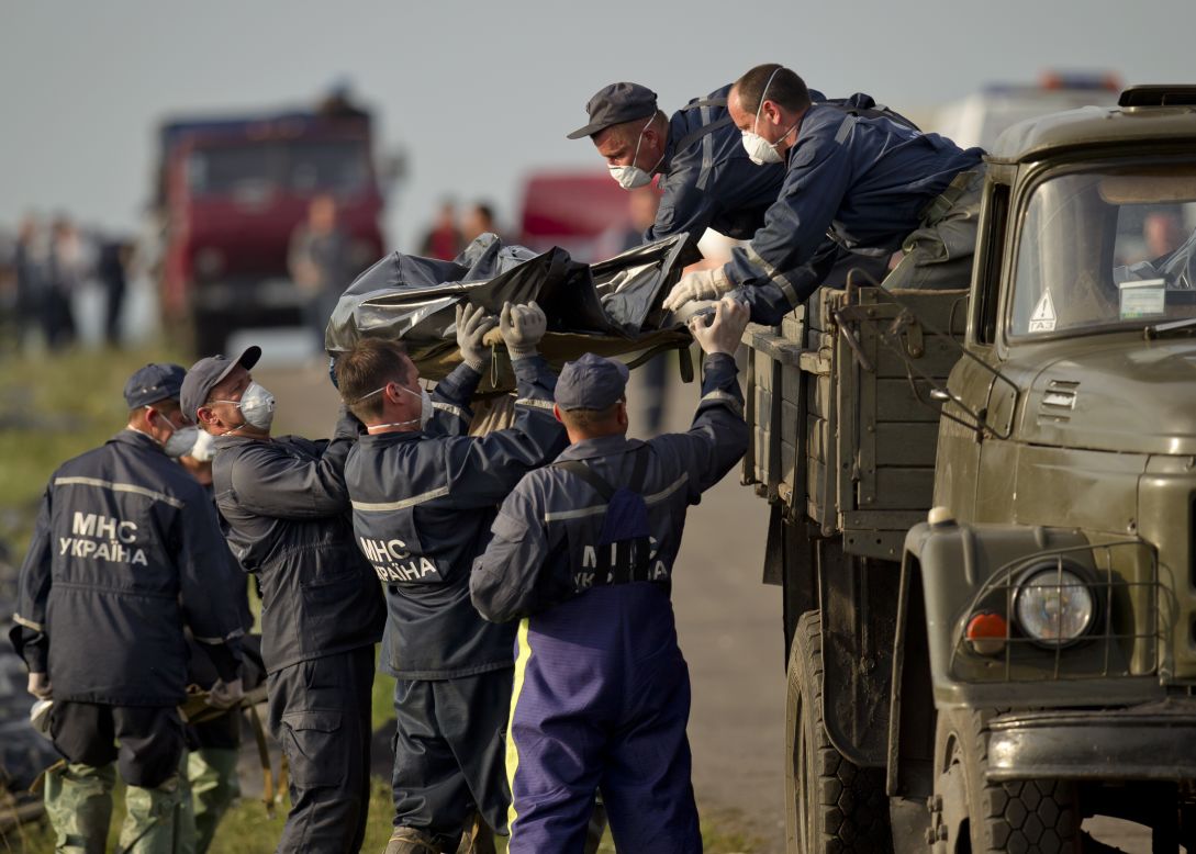 Emergency workers load the body of a victim onto a truck at the crash site on Saturday, July 19, 2014. 