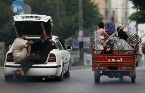 Palestinians flee their homes as Israeli troops focus their firepower on the Gaza town of Shaja'ia on Sunday, July 20. The shelling and bombing killed at least 60 people and wounded 300, according to the Gaza Health Ministry.