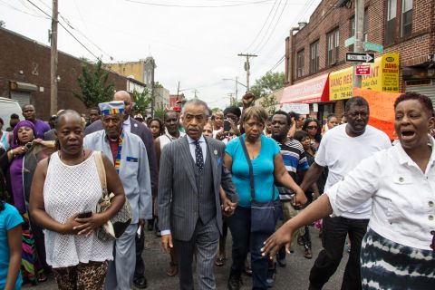People participate in a demonstration against the death of Eric Garner after he was taken into police custody in Staten Island.<a href="http://ireport.cnn.com/docs/DOC-1153998"> Joel Graham</a> photographed the July 2014 demonstration, and captured this image of Garner's friends and family rallying alongside the Rev. Al Sharpton.