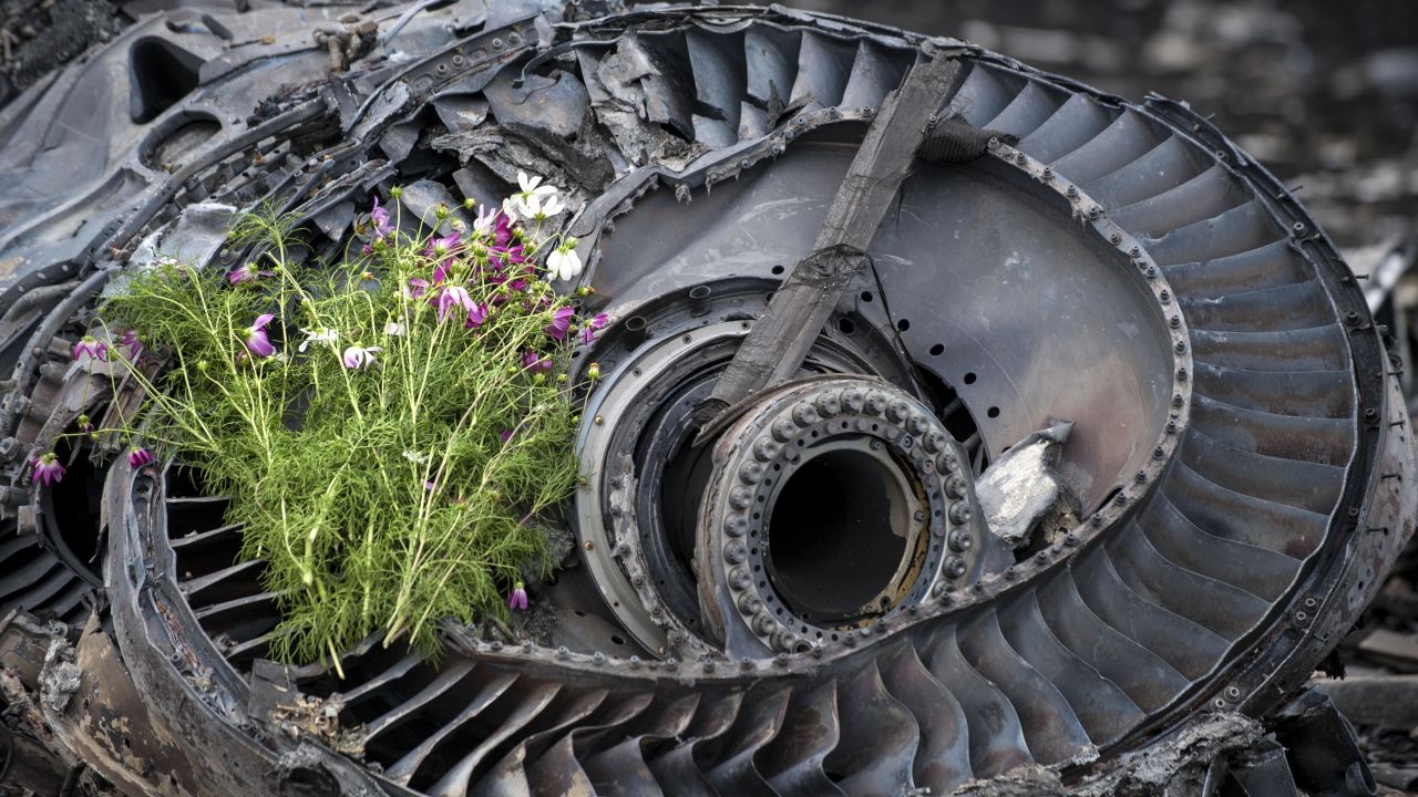 Wildflowers lie on an engine from the crashed jet on Saturday, July 19.