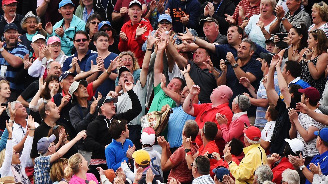 Spectators try to catch McIlroy's ball after he threw it into the stands following his victory on Sunday, July 20.