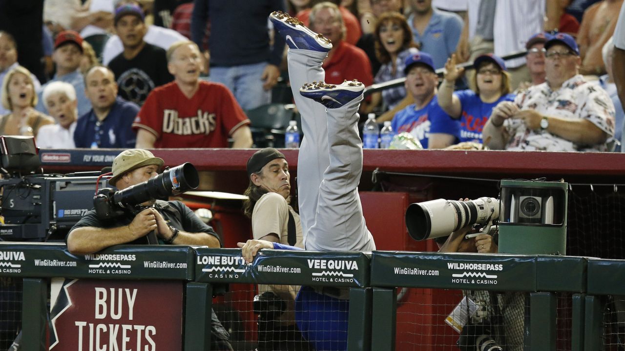 Photographers try to avoid Anthony Rizzo of the Chicago Cubs as he dives to catch a foul ball Sunday, July 20, in Phoenix.