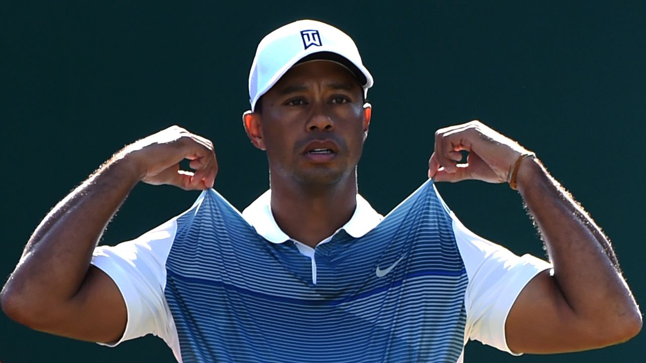 Tiger Woods adjusts his shirt before teeing off Thursday, July 17, at the British Open in Hoylake, England. Woods finished the tournament in 69th place, 23 strokes behind winner Rory McIlroy.