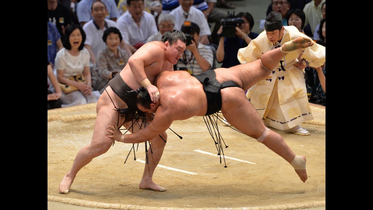 Mongolian sumo champion Hakuho, left, throws Osunaarashi at the Grand Sumo Tournament in Nagoya, Japan, on Sunday, July 20. Hakuho was seeking the 30th tournament victory of his career.