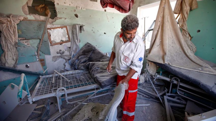 A Palestinian Red Crescent medic collects items from a hospital room damaged by Israeli shelling in central Gaza.