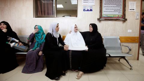 Palestinian women wait to be evacuated from the hospital on Monday.