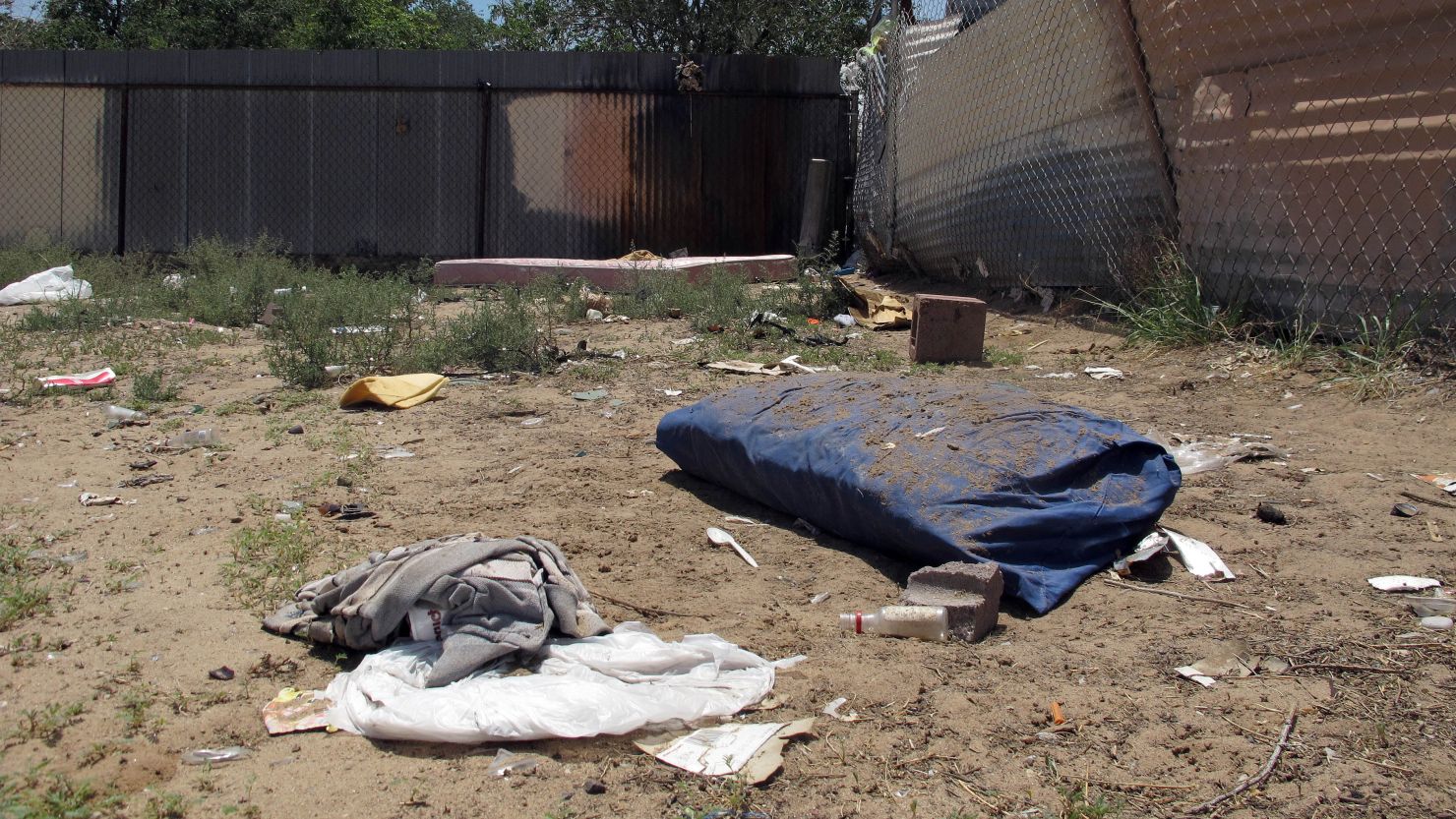 Bedding, clothing and broken glass litter a homeless encampment in Albuquerque where three teenagers are accused of fatally beating two homeless men.