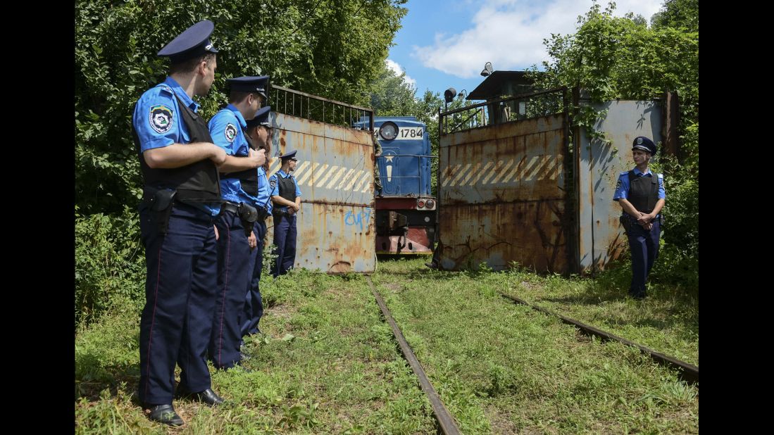 Police secure a refrigerated train loaded with bodies of passengers from Malaysia Airlines Flight 17 as it arrives in a Kharkiv, Ukraine, factory on July 22, 2014. 