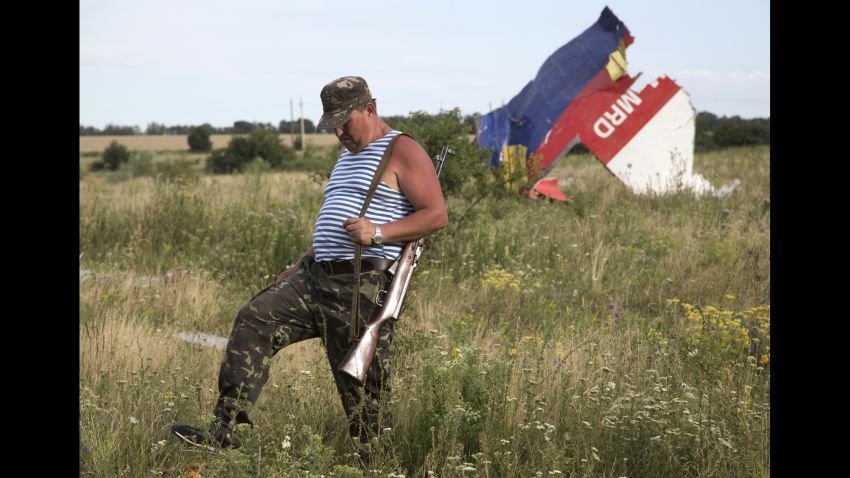 A pro-Russia rebel walks past a piece of the crashed jet in eastern Ukraine on Monday, July 21.