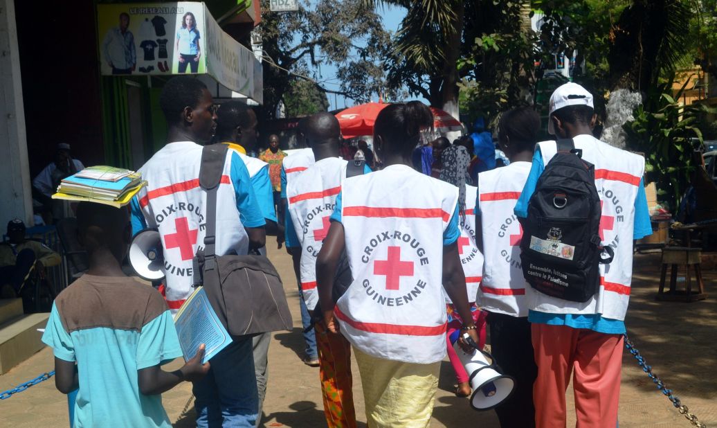 People can be infected by others if they come into contact with body fluids from an infected person or contaminated objects from infected persons. Pictured, Guinean Red Cross members spread awareness about the Ebola virus.