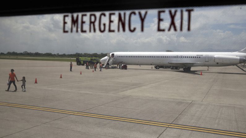 In this handout released by the Honduran government on Friday, July 18, a woman and her son walk on the tarmac after landing at Ramon Villeda Morales International Airport in Honduras. They were among the first group of Central Americans sent home under stepped-up U.S. efforts to crack down on illegal immigration.