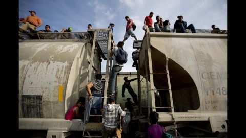 Central American migrants climb on a northbound train during their journey toward the U.S.-Mexico border in Ixtepec, Mexico, on Saturday, July 12.