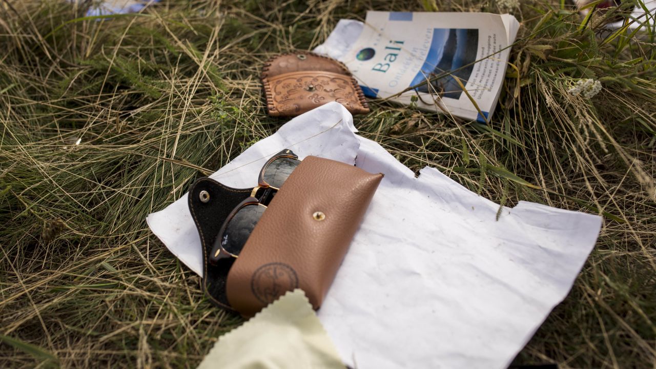 More sunglasses and a travel guide lie in the field on July 22.