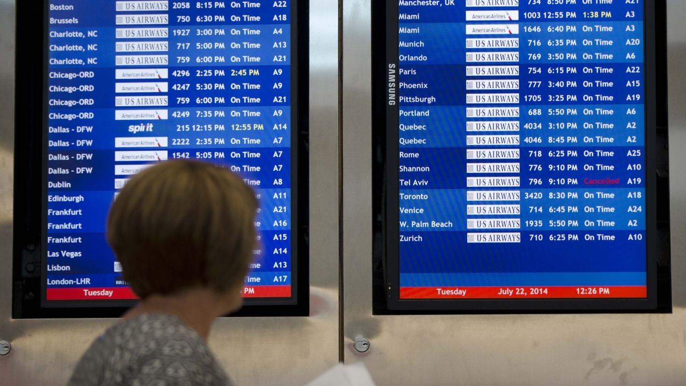 A woman in Philadelphia passes by a departure board that shows US Airways Flight 796, scheduled to fly to Tel Aviv, has been canceled on Tuesday, July 22. The Federal Aviation Administration told U.S. airlines they were temporarily prohibited from flying to the Tel Aviv airport after a Hamas rocket exploded nearby. 