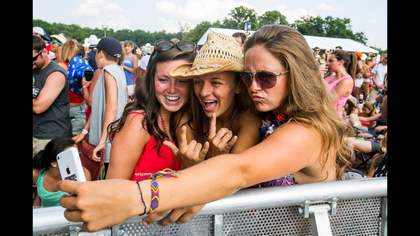 People attending the Faster Horses Festival take a selfie Sunday, July 20, at Michigan International Speedway in Brooklyn, Michigan. The country music festival included performances by Tim McGraw, Keith Urban and Miranda Lambert.