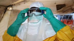 A picture taken on June 28, 2014 shows a member of Doctors Without Borders (MSF) putting on protective gear at the isolation ward of the Donka Hospital in Conakry, where people infected with the Ebola virus are being treated. The World Health Organization has warned that Ebola could spread beyond hard-hit Guinea, Liberia and Sierra Leone to neighbouring nations, but insisted that travel bans were not the answer.