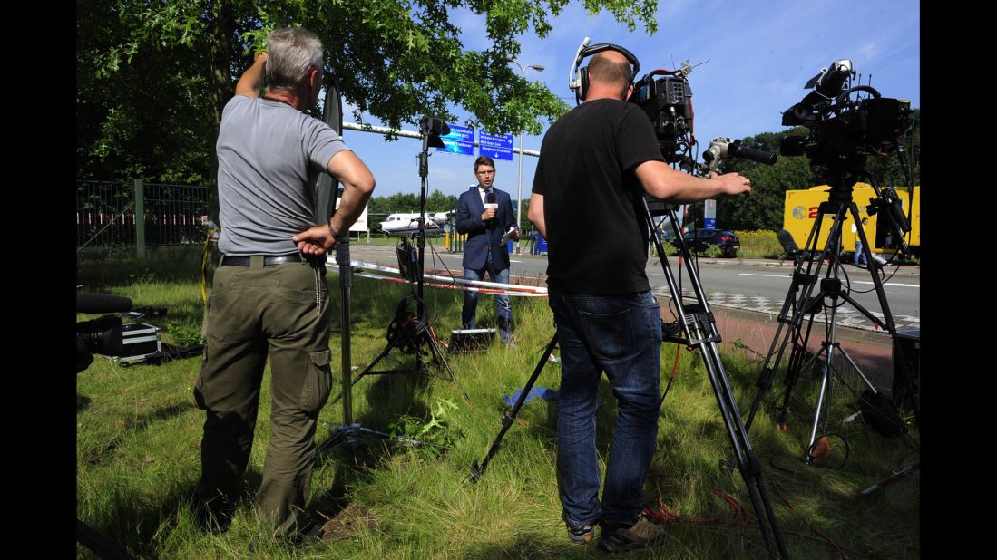 As they wait for victims' bodies to arrive on July 23, members of the media report in front of a military airport in Eindhoven.
