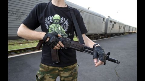 An armed pro-Russian rebel stands guard next to a refrigerated train in Torez, Ukraine, on Sunday, July 20.