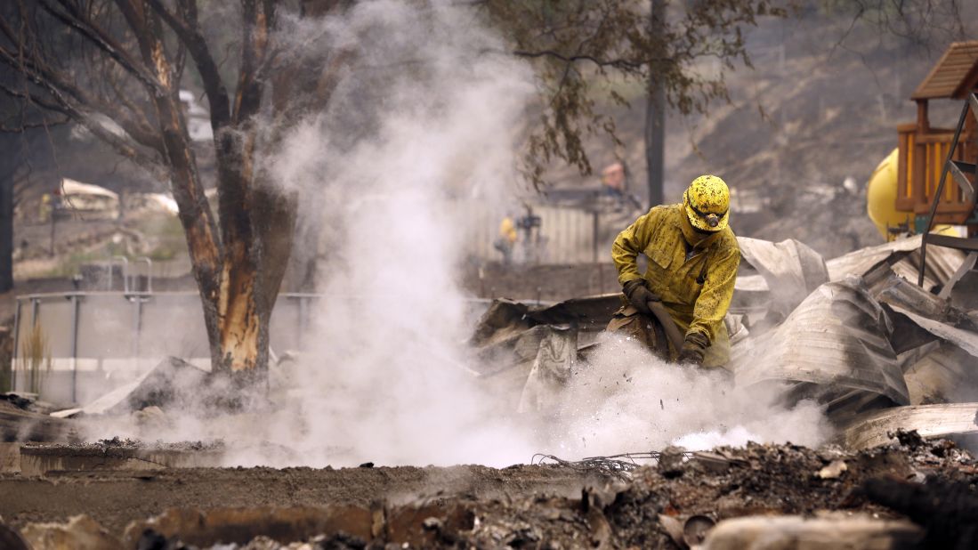 A firefighter works on the still-smoldering home of Pateros Mayor Libby Harrison on July 18.