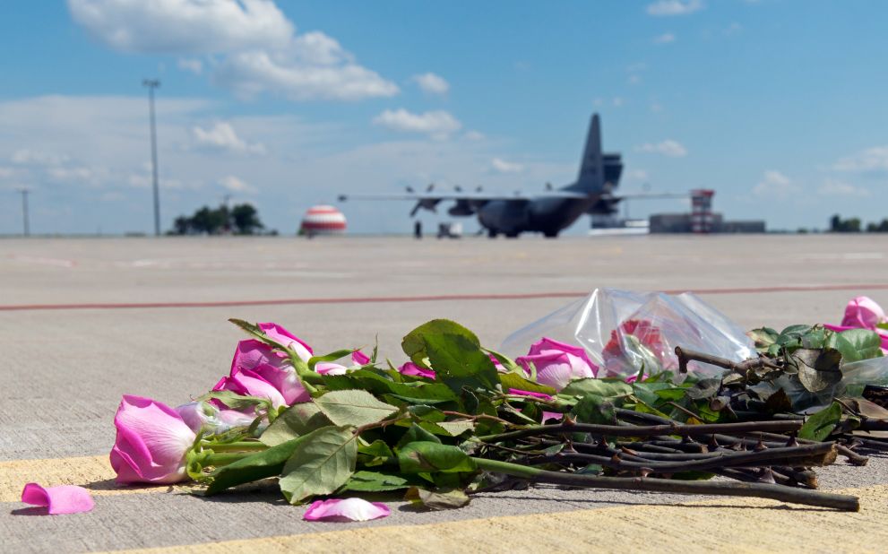 Flowers lie on the tarmac as a Hercules transport aircraft of the Royal Dutch Air Force prepares to take off from Kharkiv airport.